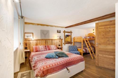 a bedroom with a bed and a wooden wall at Souvenir au Moulin in Aymavilles