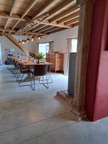 a long dining room with a long table and chairs at Gîte Les 3 pierres in Houffalize