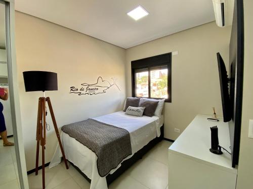 ein kleines Schlafzimmer mit einem Bett und einem Schreibtisch in der Unterkunft 32A Estudio perto do HC in Marília