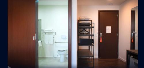 a bathroom with a toilet and a glass door at Intercity São Paulo Anhembi in Sao Paulo