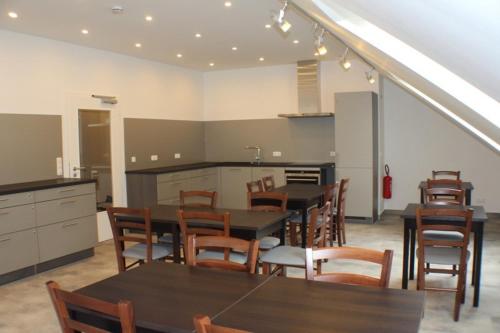 a kitchen with tables and chairs in a room at Slamba Hostel in Augsburg