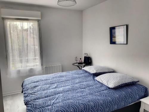 - une chambre avec un lit bleu et 2 oreillers dans l'établissement Appartement La Teste-de-Buch, à La Teste-de-Buch