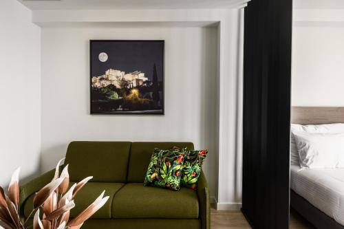 a living room with a green couch and a bed at Hestia - Averof 7 in Athens