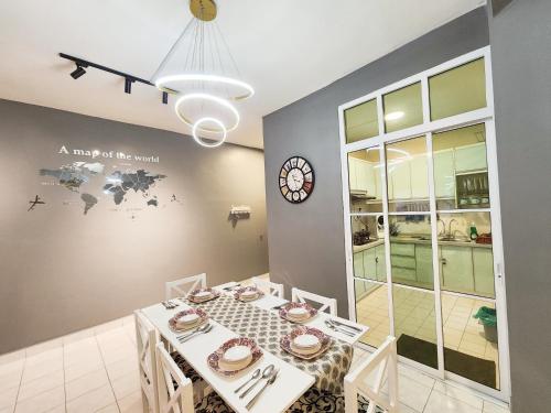 a dining room with a table and a clock on the wall at U8 TAMAN BUKIT JELUTONG, SECTION U8, 40150 SHAH ALAM Fully Air-Con Suite in Shah Alam