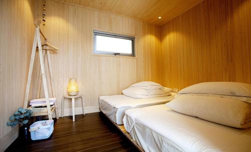 1 dormitorio con 2 camas, ventana y escalera en Namhae Bay 591, en Namhae
