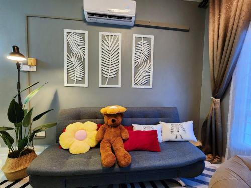 un orsacchiotto seduto su un divano in soggiorno di Shah Alam U8 FULLY AIR-CON Suite a Shah Alam