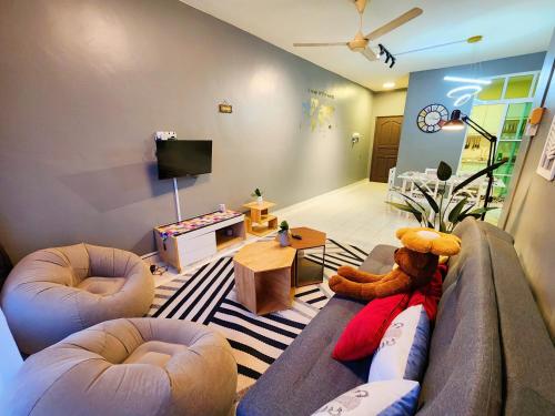 a living room with a teddy bear sitting on a couch at Shah Alam U8 FULLY AIR-CON Suite in Shah Alam