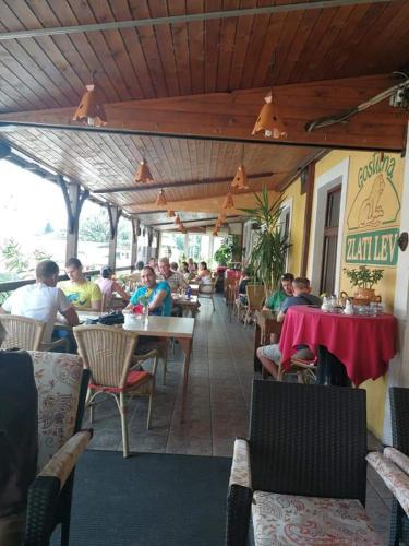 a group of people sitting at tables in a restaurant at Gostilna in apartmaji Zlati lev - Maribor in Maribor