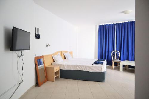 a bedroom with a bed and a tv in it at Къща за гости "Arawana" in Sunny Beach
