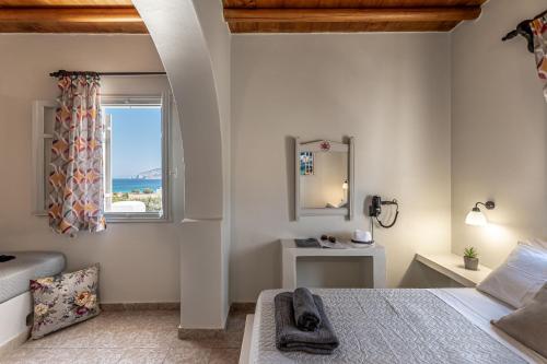 een slaapkamer met een bed en een raam bij Michalios Luxury Apartments in Koufonisia