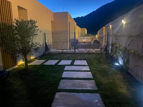 a garden at night with a stone walkway at Le bellevue apartment in Llogara