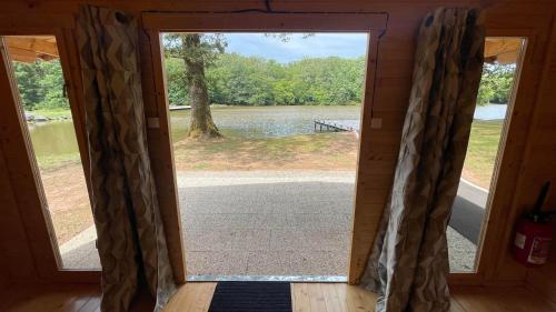 a door to a screened in porch with a view of a lake at Hébergement au bord de l'eau 