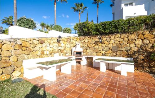 a patio with two benches and a stone wall at Lovely Apartment In Mijas With Wifi in Mijas