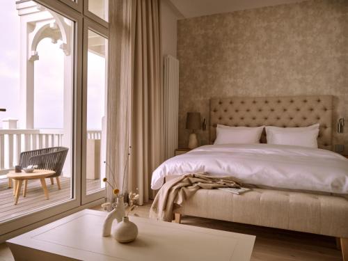 a bedroom with a large bed and a balcony at 1884 Norderney in Norderney
