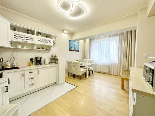 a kitchen with white cabinets and a dining room at 135m2 new apartment 5 rooms with airport pickup in Ulaanbaatar