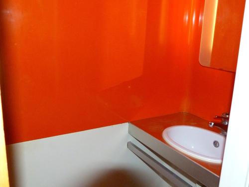 baño con pared de color naranja y lavamanos en Appartement Les Arcs 1800, 3 pièces, 8 personnes - FR-1-411-383, en Arc 1800