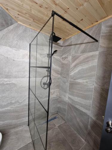 a shower with a glass wall in a room at A Frame Chalet By Superski in Cavnic