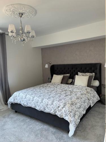 a bedroom with a large bed with a chandelier at Forest Villa in Saint-Clair-de-Halouze