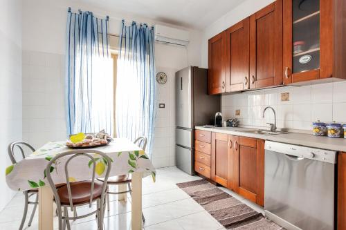cocina con mesa con sillas y fregadero en casa Simona en Catania