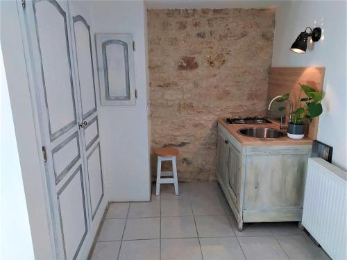 a small kitchen with a sink and a door at Maison Les Chandelles in Loupiac