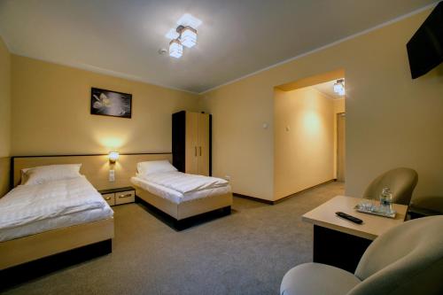 a hotel room with two beds and a couch at Zajazd Sanocki in Sanok