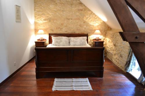 a bedroom with a bed and two lamps on two tables at Maison Les Chandelles in Loupiac