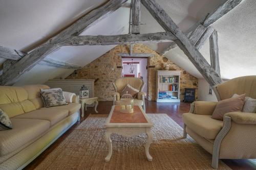 a living room with two couches and a table at Maison Les Chandelles in Loupiac