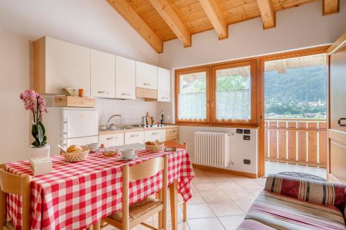 cocina con mesa y mantel rojo y blanco en Sarca Lodge Val Rendena, en Dare