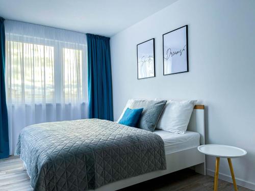 um quarto com uma cama com paredes azuis e uma janela em LAWIS Apartments em Poprad