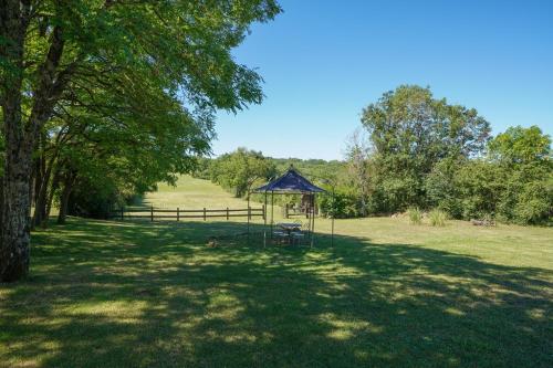 a gazebo in the middle of a field with trees at Maison Les Chandelles in Loupiac