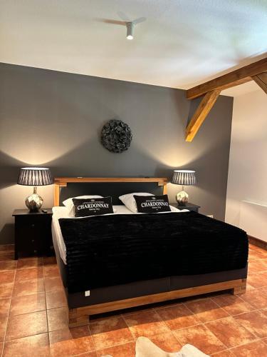 a bedroom with a black bed with two lamps at Hotel Henriettenhof Weimarer Land, Weimar-Bad Berka in Bad Berka