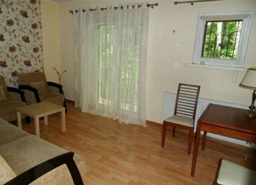 - un salon avec une table, des chaises et un bureau dans l'établissement Apartament wakacyjny Sopot, à Sopot