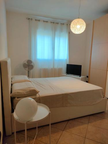 una camera con letto, sedia e televisore di Dante Blu a Ravenna