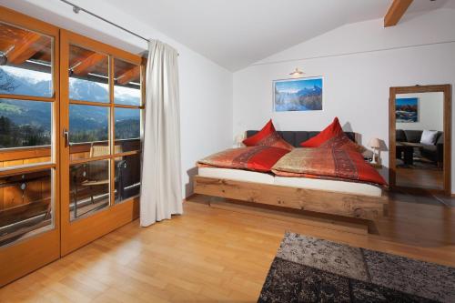 ビショフスヴィーゼンにあるSonnenscheinのベッドルーム1室(赤い枕のベッド1台付)