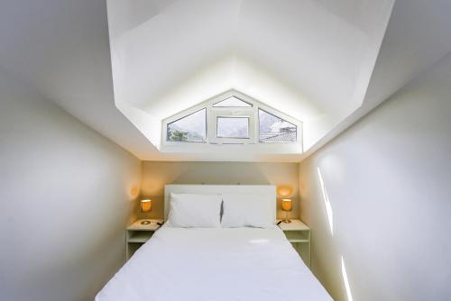 een bed in een kleine kamer met een raam bij Modern Flat w Balcony 5 min to Beach in Kemer in Antalya