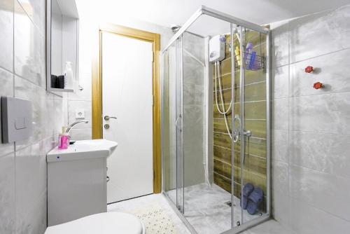 een badkamer met een douche, een toilet en een wastafel bij Modern Flat w Balcony 5 min to Beach in Kemer in Antalya