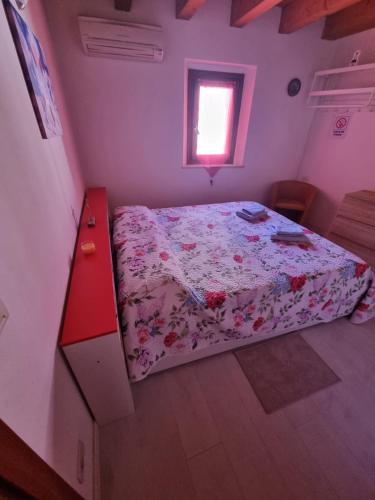um quarto com uma cama com uma gaveta vermelha e uma janela em Monolocale in centro storico a grado em Grado