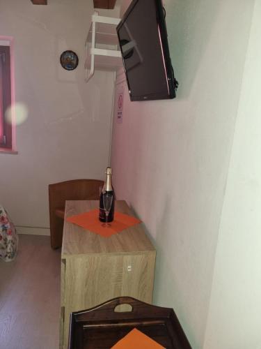 um quarto com uma mesa com uma garrafa de vinho em Monolocale in centro storico a grado em Grado