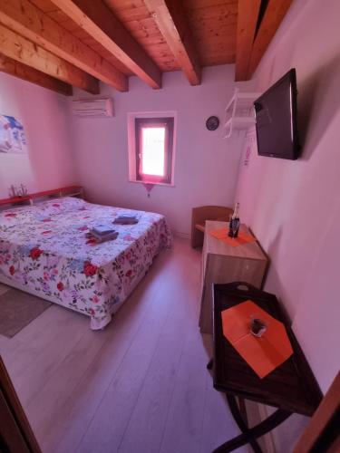 um pequeno quarto com uma cama e uma janela em Monolocale in centro storico a grado em Grado