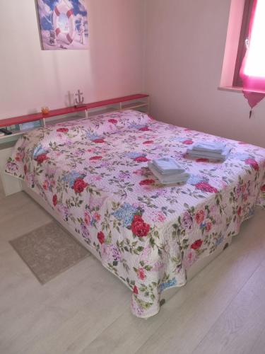 uma cama num quarto com uma colcha floral em Monolocale in centro storico a grado em Grado