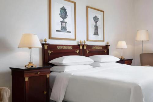 a bedroom with two beds with white sheets and two lamps at Sheraton Diana Majestic in Milan