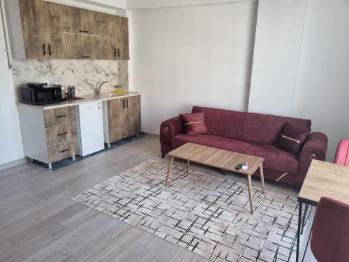 a living room with a purple couch and a table at istanbul airport family suites hotel in Arnavutköy