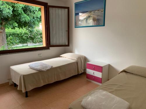 Zimmer mit 2 Betten und einem Fenster in der Unterkunft Casa Vacanze Stella Marina in Monte Nai