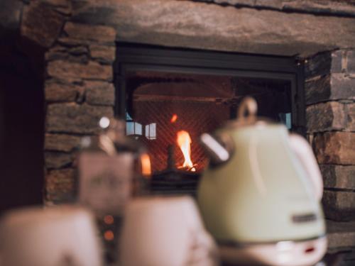 a tea kettle in front of a fireplace at B&B Ca' Mea room, wellness & food in Levata