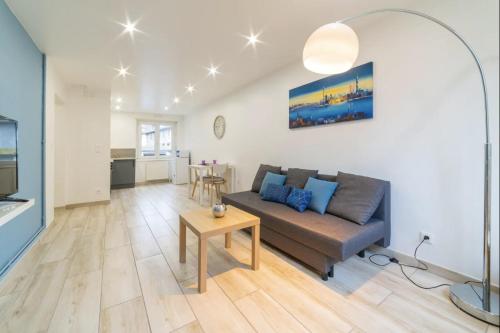 un salon avec un canapé et une table dans l'établissement JUST FOR YOU - Balcon - Parking - Calme- Fibre - RELAX BNB, à Mulhouse