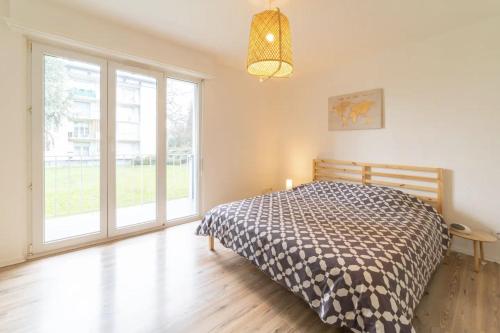 une chambre avec un lit et une grande fenêtre dans l'établissement JUST FOR YOU - Balcon - Parking - Calme- Fibre - RELAX BNB, à Mulhouse