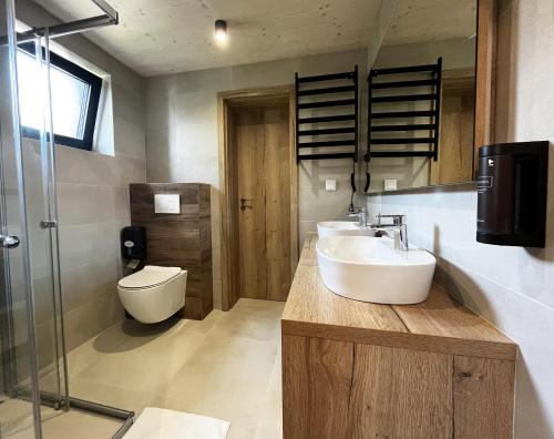 a bathroom with two sinks and a toilet at Rezidencia Hrabovo SKI IN-OUT in Ružomberok