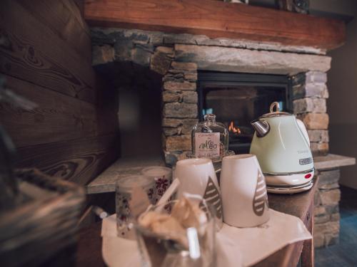 a counter with a fireplace with a toaster and cups at B&B Ca' Mea room, wellness & food in Levata