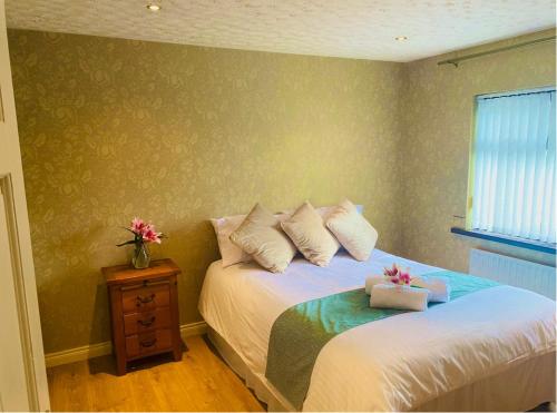 a bedroom with two beds with pillows and a table at Glenview Cottage in Keady