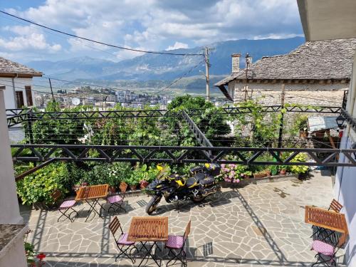 Blick auf eine Terrasse mit Stühlen und einem Motorrad in der Unterkunft Palorto Traditional Hotel in Gjirokastër